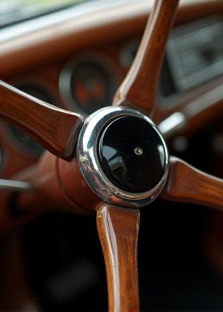 Détail d'un volant en bois et en bakélite restauré avec soin.